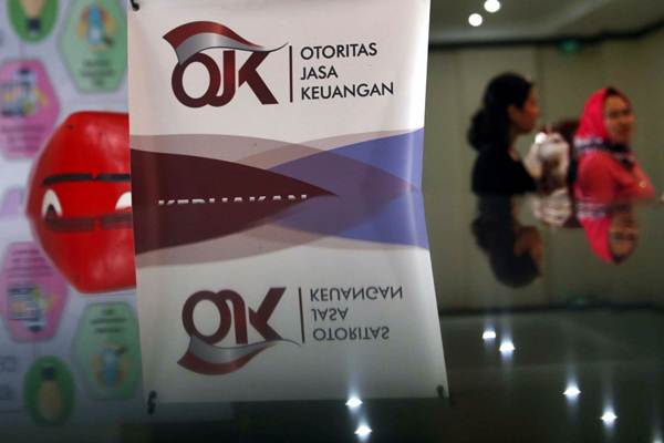 Karyawan melintas di dekat logo Otoritas Jasa Keuangan (OJK) di Jakarta, Rabu (3/10/2018)./JIBI-Nurul Hidayat