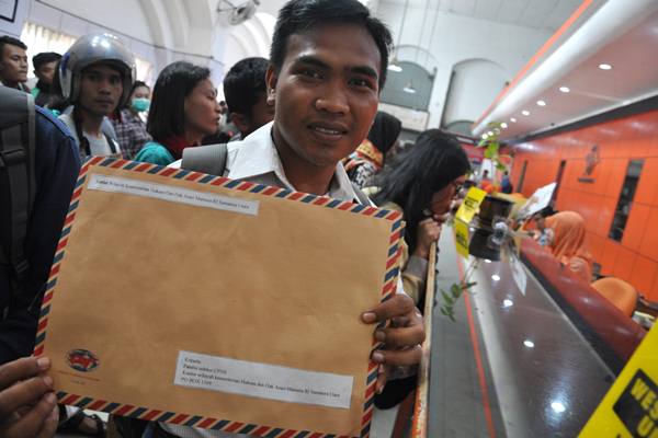 Seorang pelamar calon pegawai negeri sipil (CPNS) memperlihatkan berkas pendaftaran lamarannya untuk dikirim di Kantor Pos Besar Medan, Sumatera Utara, Senin (15/10). /Antara