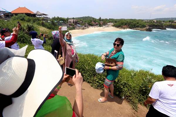 Wisatawan berfoto dengan latar pemandangan Dream Beach, Nusa Lembongan, Bali, Rabu (21/3/2018)./JIBI-Rachman