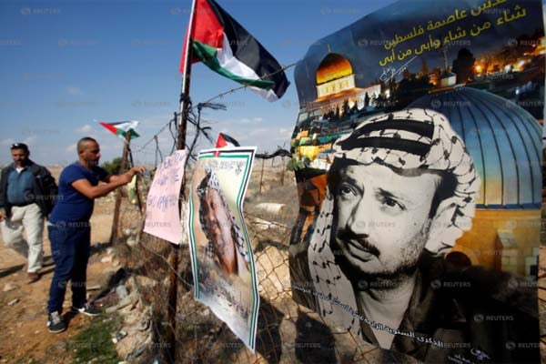 Poster pendiri Palestina mendiang Yasser Arafat terpampang di sejumlah lokasi di Hebron./Reuters-Mussa Qawasma