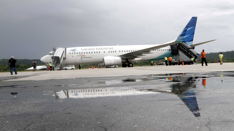 Penumpang bersiap menaiki pesawat maskapai penerbangan Garuda Indonesia di Bandara Frans Kaisiepo Biak, Papua, Selasa (29/10/2013). /Bisnis-Dwi Prasetya