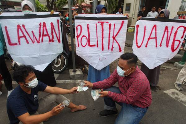  Mahasiswa melakukan teatrikal ketika menggelar aksi Lawan Politik Uang di Jalan Urip Sumoharjo Solo, Jawa Tengah, Selasa (26/6)./Antara