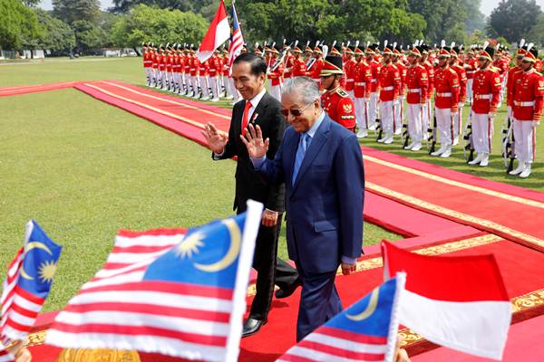 Presiden Joko Widodo (kiri) dan Perdana Menteri Malaysia Mahathir Muhamad melambaikan tangan kepada para pelajar, di sela-sela upacara penyambutan di Istana Bogor, Jawa Barat, Jumat (29/6/2018)./Reuters-Darren Whiteside