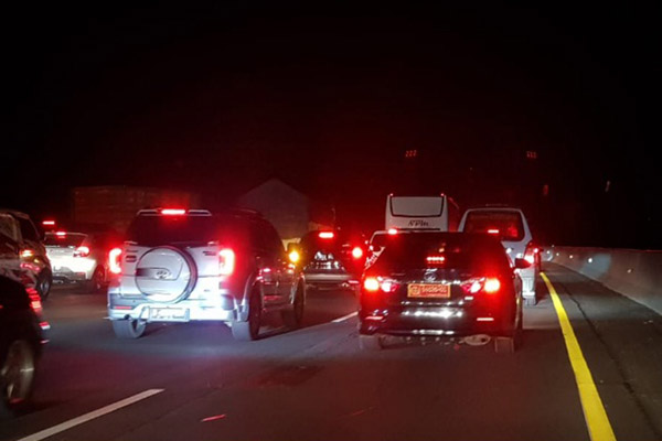 Kendaraan berjalan merayap di jalan tol Cikampek mengarah Jakarta di KM 64 pada Selasa (1/1/2019) tengah malam./Bisnis-Chamdan PUrwoko