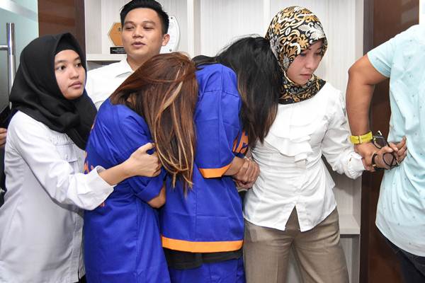 Polisi wanita menggiring dua tersangka muncikari dari prostitusi daring artis dan model Endang alias Siska (ES) dan Tantri (TN) ketika ungkap kasus di Subdit V Siber Ditreskrimsus Polda Jawa Timur, Kamis (10/01/2019)./ANTARA-M Risyal Hidayat
