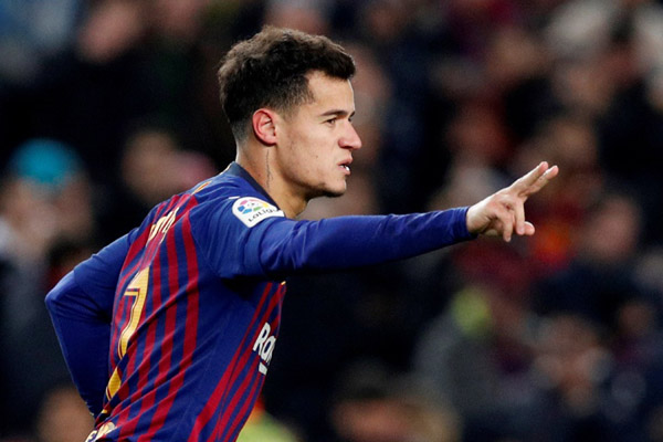 Gelandang serang Philippe Coutinho selepas mencetak gol ketiga Barcelona ke gawang Sevilla seraya mengacungkan dua jarinya menunjukkan bahwa dia mencetak dua gol./Reuters-Albert Gea