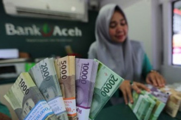 Seorang karyawati menghitung uang di salah satu kantor cabang Bank Aceh Syariah./Antara-Irwansyah Putra