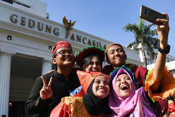 Sejumlah mahasiswa berbusana tradisional berswafoto seusai mengikuti upacara Hari Lahir Pancasila di depan Gedung Pancasila, Kementerian Luar Negeri, Jakarta, Jumat (1/6/2018)./ANTARA-Puspa Perwitasari