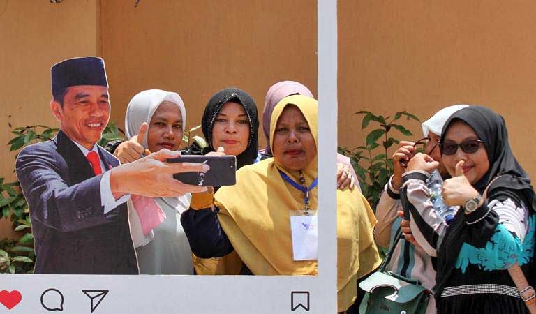 Pendukung calon Presiden nomor urut 01 Joko Widodo  Maruf Amin berfoto dengan spot photo Jokowi usai kampanye terbuka Jokowi di Lhokseumawe, Aceh, Selasa (26/3/2019)./ANTARA-Rahmad