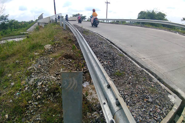 Pengguna jalan melintas di overpass jalan tol di Desa Kiringan, Boyolali Kota, Selasa (26/3/2019). Sebagian baut dan penyangga pagar pada overpass ini raib diduga dicuri. (Solopos-Akhmad Ludiyanto)