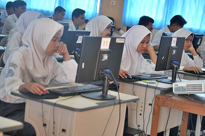 Sejumlah siswa mengerjakan soal pada Ujian Nasional Berbasis Komputer (UNBK) Sekolah Menengah Atas Kejuruan (SMK) di ruang komputer Gedung SMK Negeri 7 Palembang, Sumatra Selatan, Senin (25/3/2019)./ANTARA-Feny Selly
