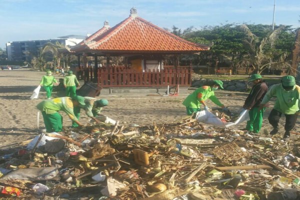 Petugas DLHK Badung membersihkan sampah di Pantai Nusa Dua./Bisnis.com - Feri Kristianto