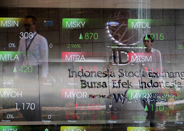 Karyawan melintas di dekat papan pergerakan Indeks Harga Saham Gabungan (IHSG) di Jakarta, Rabu (23/1/2019)./Bisnis-Felix Jody Kinarwan