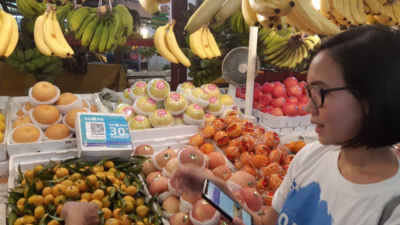 Seorang pelanggan menggunakan Go-Pay untuk berbelanja buah di Pasar Modern Town Market, Kota Tangerang pada Kamis (4/4/2019)./Bisnis-Leo Dwi Jatmiko