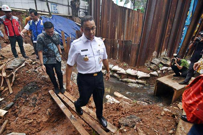 Gubernur DKI Jakarta Anies Baswedan (tengah) meninjau titik banjir yang bersebelahan dengan proyek LRT di Underpass Cawang, Jakarta, Kamis (4/4/2019)./ANTARA FOTO/Indrianto Eko Suwarso