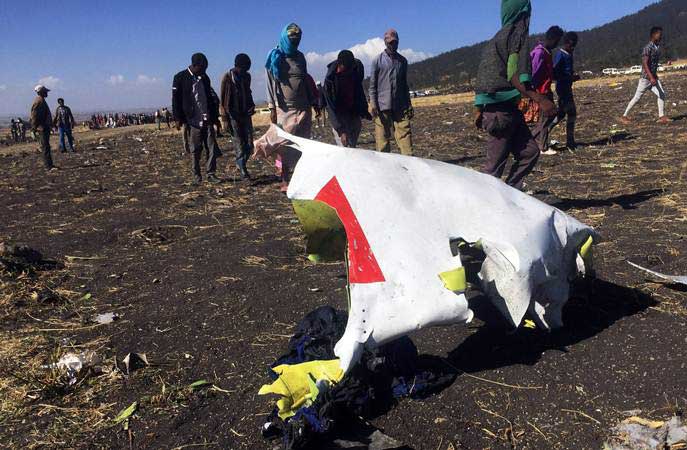 Warga berjalan di dekat puing pesawat Ethiopian Airlines dengan nomor penerbangan ET 302 yang jatuh di dekat Kota Bishoftu, 62 kilometer dari tenggara Ibukota Addis Ababa, Ethiopia, Minggu (10/3/2019)./REUTERS-Tiksa Negeri