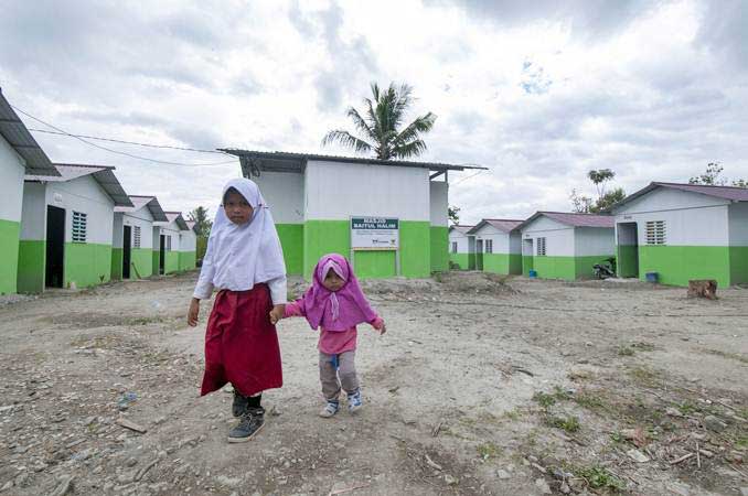 Dua orang anak korban gempa melintas di depan kompleks Hunian Sementara (Huntara) di Desa Baliase, Sigi, Sulawesi Tengah, Kamis (14/3/2019)./ANTARA-Basri Marzuki