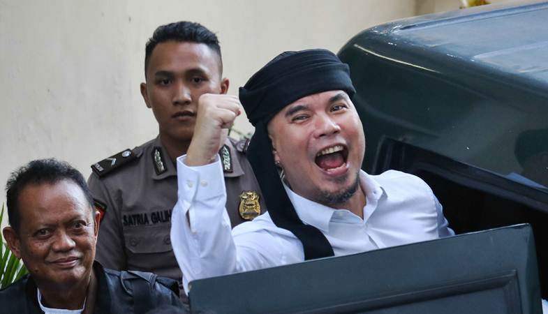 Terdakwa kasus dugaan pencemaran nama baik Ahmad Dhani Prasetyo (kanan) masuk ke mobil tahanan usai mengikuti sidang tuntutan di Pengadilan Negeri Surabaya, Jawa Timur, Selasa (23/4/2019)./ANTARA-Didik Suhartono