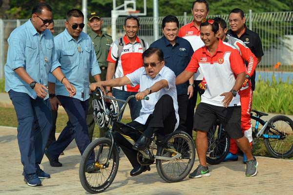 Wakil Presiden Jusuf Kalla (tengah) mencoba naik sepeda BMX ketika meninjau venue BMX di BMX International Center Pulomas, Jakarta, Jumat (29/6/2018)./ANTARA-Wahyu Putro A