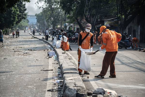 Petugas PPSU membersihkan jalan dari pecahan kaca pascabentrok polisi dan massa perusuh, di Jalan KS Tubun, Petamburan, Jakarta, Rabu (22/5/2019)./Antara
