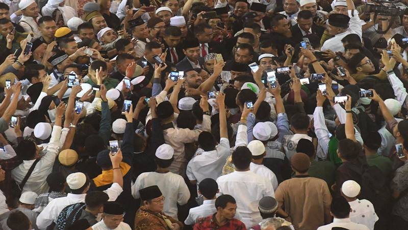 Presiden Joko Widodo (tengah) menerima ajakan swafoto warga usai melakukan Shalat Id di Masjid Istiqlal, Jakarta, Rabu (5/6/2019). Umat Islam di Indonesia merayakan datangnya Idul Fitri 1 Syawal 1440 H pada hari ini./Antara