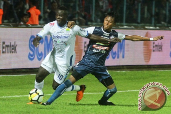 Pesepakbola Persib Bandung, Ezechiel Ndouasel (kiri) berebut bola dengan pesepakbola Arema FC, Johan Al Farisyi (kanan) dalam pertandingan GO-JEK Liga I di Stadion Kanjuruhan, Malang, Jawa Timur, Minggu (15/4/2018). (ANTARA /Ari Bowo Sucipto)    
