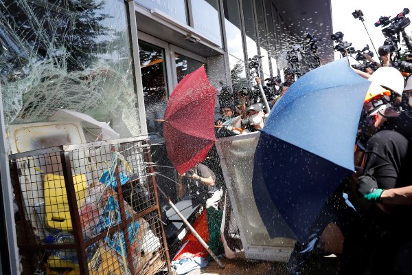 Pengunjuk rasa yang menggunakan payung mencoba masuk ke gedung Dewan Legislatif Hong Kong, Senin (1/7/2019). Unjuk rasa besar-besaran kembali terjadi di kota pelabuhan itu pada hari peringatan 20 tahun penyerahan Hong Kong dari Inggris ke China./Reuters-Tyrone Siu