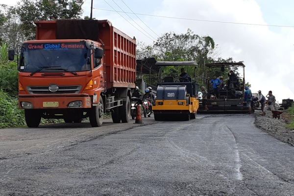 Petugas melakukan pengerjaan perbaikan jalan di Km 92 Desa Kandang Ayam, Kecamatan Babat Supat, Kabupaten Musi Banyuasin, Sumsel./Bisnis-Dinda Wulandari