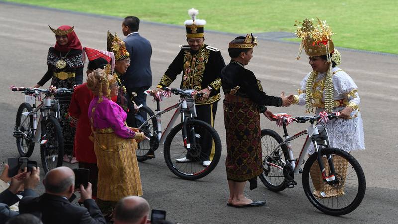Presiden Joko Widodo (kedua kanan) memberi hadiah sepeda kepada tamu undangan yang mengenakan pakaian baju adat terbaik seusai memimpin Upacara Peringatan Detik-Detik Proklamasi Kemerdekaan Indonesia ke-74 Tahun 2019 di Istana Merdeka, Jakarta, Sabtu (17/8/2019)./Antara