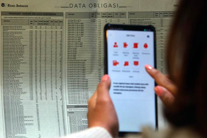 Karyawan mencari informasi tentang obligasi di Jakarta, Rabu (17/7/2019)./Bisnis-Abdullah Azzam