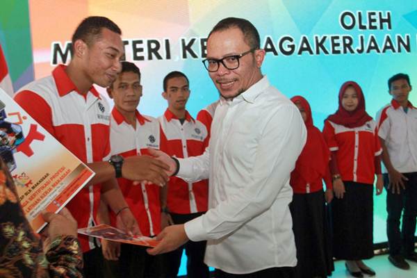 Menteri Tenaga Kerja Hanif Dhakiri (kanan) menyerahkan secara simbolis seribu sertifikat kelulusan kepada perwakilan siswa Balai Latihan Kerja (BLK) di Makassar, Sulawesi Selatan, Rabu (17/10/2018)./JIBI-Paulus Tandi Bone