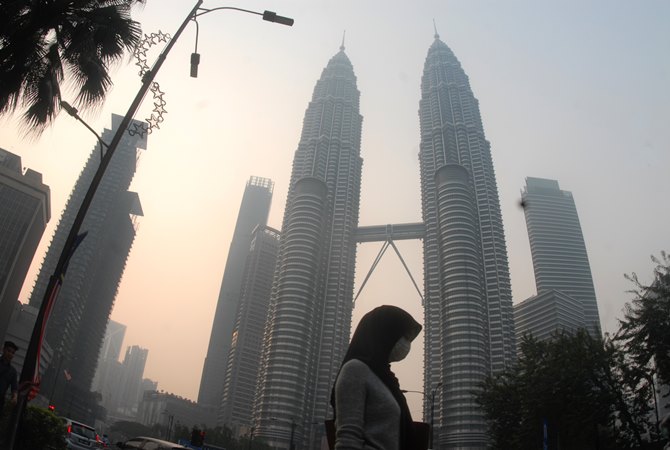 Warga beraktivitas dengan mengenakan masker di dekat menara kembar Petronas, Kuala Lumpur, Malaysia, Selasa (10/9/2019)./ANTARA - Rafiuddin Abdul Rahman