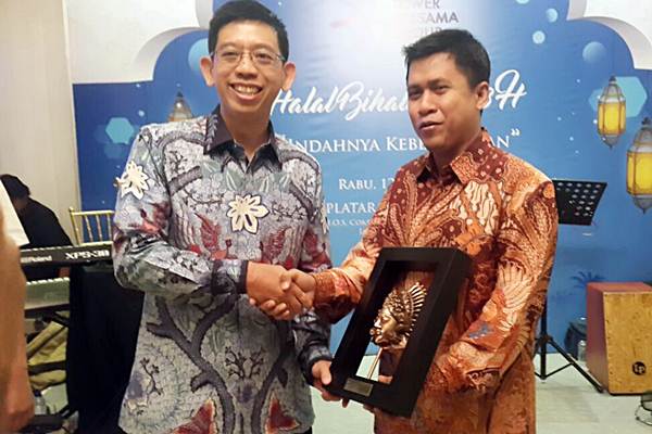 Direktur PT Tower Bersama Infrastructure Tbk Helmy Yusman Santoso (kiri) menyerahkan penghargaan kepada Pemimpin Redaksi Bisnis Indonesia Hery Trianto, di Jakarta, Rabu (12/7). Bisnis Indonesia mendapat penghargaan The Most Active & Positive Media 2017 dari Tower Bersama Group./JIBI-Endang Muchtar