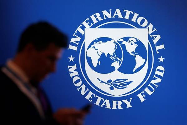 Peserta berdiri di dekat logo Dana Moneter Internasional (IMF) dalam rangkaian Pertemuan IMF  World Bank Group 2018, di Nusa Dua, Bali, Jumat (12/10/2018)./Reuters-Johannes P. Christo