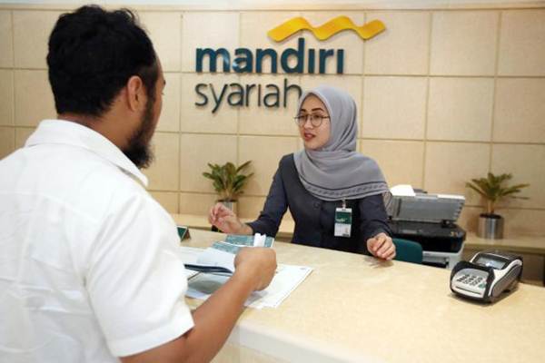Karyawan melayani nasabah di kantor cabang Bank Syariah Mandiri./JIBI-Abdullah Azzam