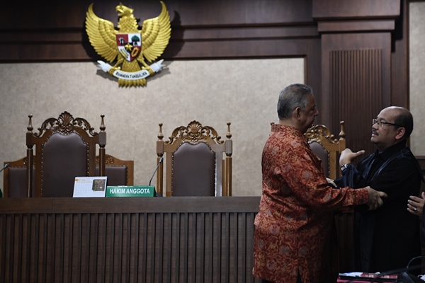 Mantan Dirut PLN Sofyan Basir (kiri) berjabat tangan dengan kuasa hukumnya usai pembacaan putusan di Pengadilan Tipikor, Jakarta, Senin (4/11/2019). Majelis hakim memvonis bebas Sofyan Basir/ANTARA FOTO-Puspa Perwitasari