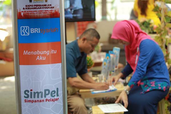 Petugas memberikan penjelasan kepada pengunjung di stan peserta IB Vaganza Expo Keuangan Syariah di Jakarta, Jumat (5/10/2018)./JIBI-Dwi Prasetya
