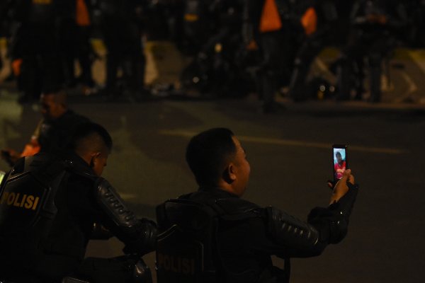 Seorang anggota Brimob Polda Kalimantan Utara Jufri melakukan telepon video dengan anaknya saat beristirahat sejenak dari pengamanan aksi unjuk rasa di depan gedung Parlemen, Jakarta, Senin (30/9/2019)./ANTARA FOTO-Indrianto Eko Suwarso