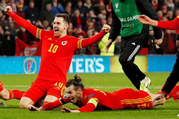 Dua pemain andalan Wales, Aaron Ramsey (kiri) dan Gareth Bale, merayakan kesuksesan timnya lolos ke putaran final Euro 2020./Reuters-Andrew Boyers