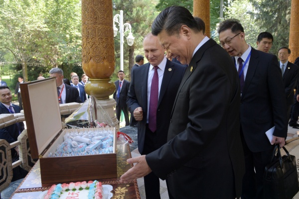 Presiden Rusia Vladimir Putin (kiri) memberikan es krim kepada Presiden China Xi Jinping sebagai hadiah ulang tahun sebelum konferensi Interaction and Confidence-Building Measures in Asia (CICA) di Dushanbe, Tajikistan (15/6/2019)./Reuters