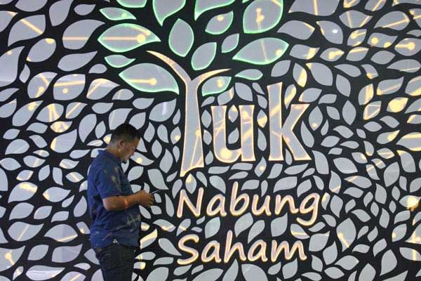 Pengunjung beraktivitas di dekat tulisan Yuk Nabung Saham, di Jakarta, Kamis (3/1/2019)./Bisnis-Dedi Gunawan