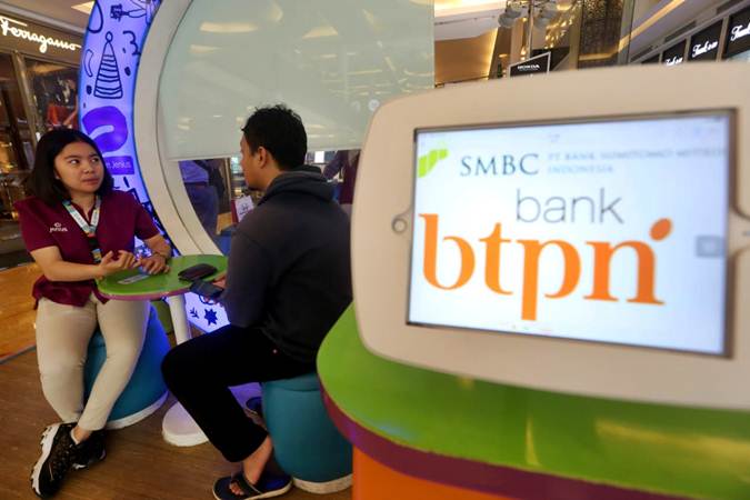 Petugas menjelaskan produk Jenius, aplikasi teknologi finansial (tekfin) milik Bank Tabungan Pensiunan Nasional (BTPN), kepada pengunjung di salah satu pusat perbelanjaan di Bandung, Jawa Barat, Senin (22/7/2019)./Bisnis-Rachman