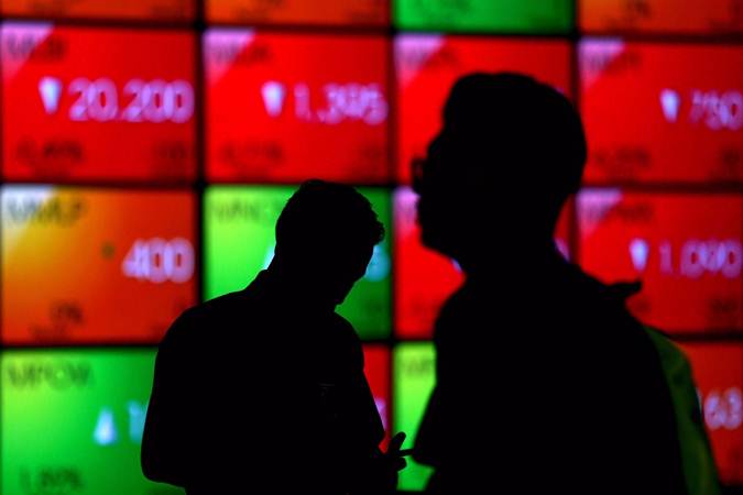 Siluet karyawan di dekat layar monitor pergerakan Indeks Harga Saham Gabungan (IHSG) di Bursa Efek Indonesia, Jakarta, Kamis (13/6/2019)./Bisnis-Nurul Hidayat