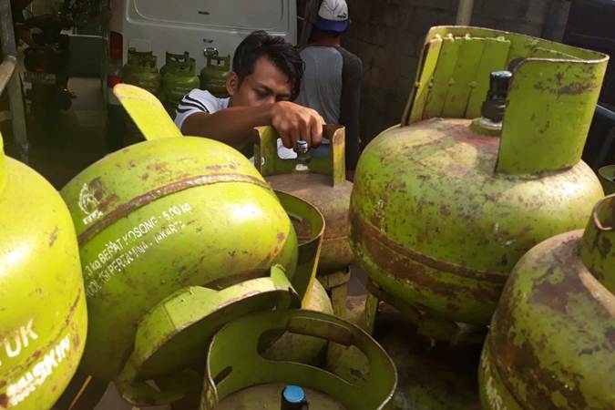 Pekerja membongkar tabung gas LPG 3kg di salah satu agen penjualan, di Jakarta, Selasa (2/7/2019)./Bisnis-Endang Muchtar