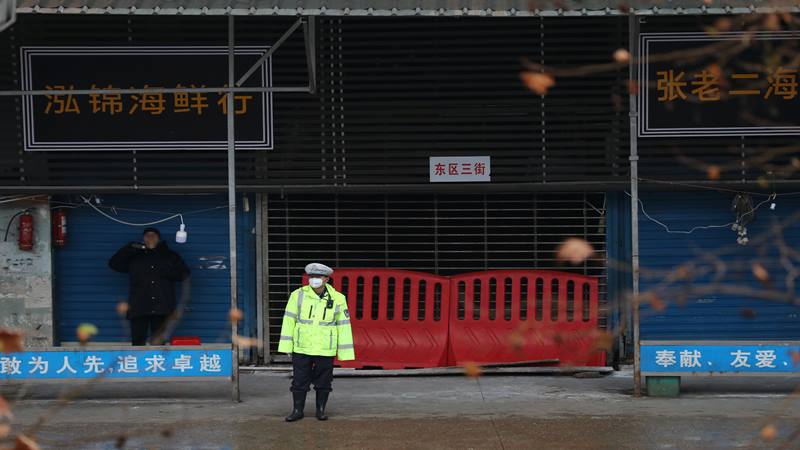 Seorang petugas polisi mengenakan masker berdiri di depan pasar makanan laut di Wuhan, Provinsi Hubei, China 10 Januari 2020. Pasar makanan tersebut dihubungkan dengan wabah pneumonia yang disebabkan oleh strain baru coronavirus, tetapi beberapa pasien didiagnosis terinfeksi coronavirus baru tidak berkunjung ke pasar ini. Foto diambil 10 Januari 2020./Reuters