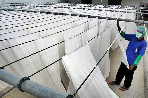 Pekerja menjemur kain kasa di sebuah industri pembuatan kain kasa, Kabupaten Pekalongan, Jawa Tengah, Jumat (24/2)./Antara-Harviyan Perdana Putra