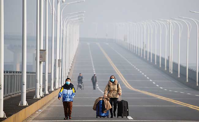Warga tiba dari Provinsi Hubei saat melintasi pos pemeriksaan di Jembatan Sungai Jiujiang Yangtze di Jiujiang, Provinsi Jiangxi, China, Jumat (31/1/2020). Reuters/Thomas Peter