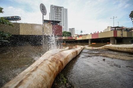 Selang air memompa banjir yang menutup Underpass Kemayoran, Jakarta, Minggu (2/2/2020). Banjir di kawasan tersebut diakibatkan intensitas hujan yang tinggi dan drainase yang buruk. ANTARA FOTO/Rivan Awal Lingga/foc.