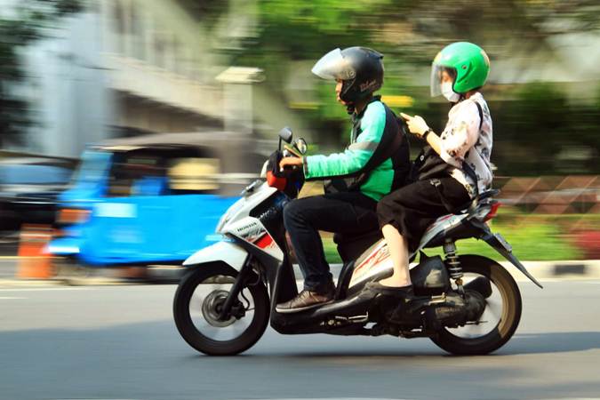 Pengemudi ojek daring atau ojek online (Ojol) mengantar penumpang melintas di kawasan Monumen Nasional, Jakarta, Rabu (12/6/2019)./Bisnis-Triawanda Tirta Aditya