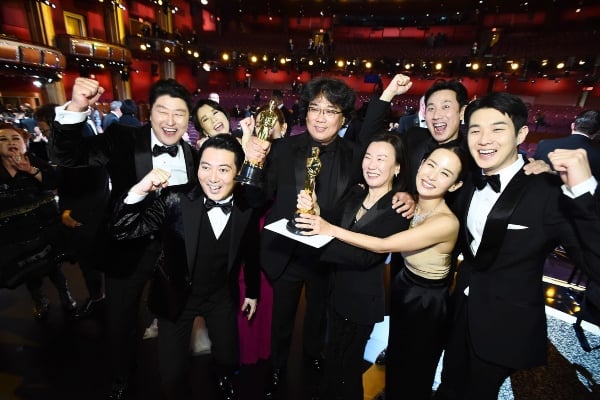 Para aktor, aktris, dan kru film Parasite berfoto bersama usai memenangkan Piala Oscar sebagai Film Terbaik pada Minggu (9/2/2020). - Bloomberg